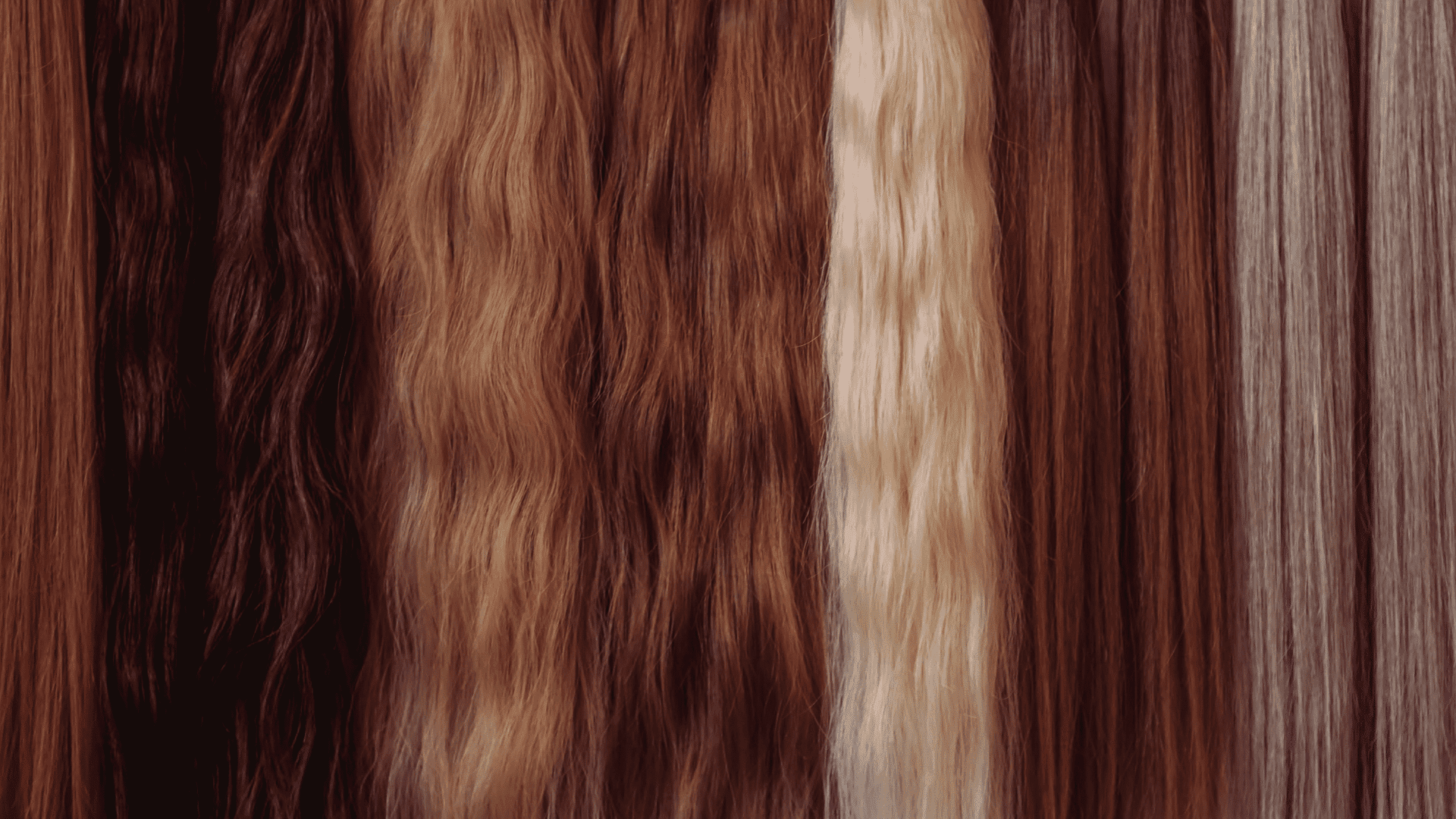 Various shades of natural hair extensions displayed in vertical rows.